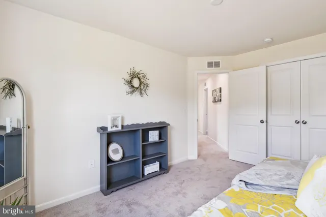 a bed sitting in a bedroom next to a window and a lamp