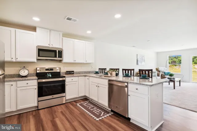 a kitchen with a sink cabinets and wooden floor