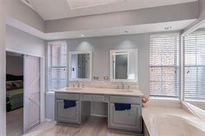 4050 Frankford Road, Unit 908 Dallas, TX 75287 - Photo 10 of 16 Dual vanity with undermount sinks, light-toned countertop, and framed mirrors