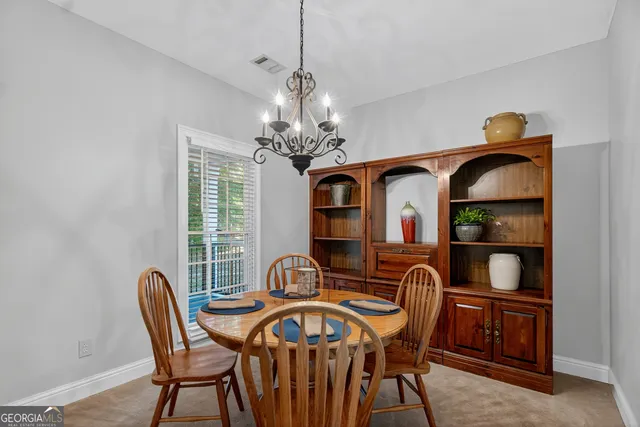 a view of a dining room with furniture and chandelier