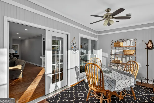 a view of a livingroom with furniture a ceiling fan and wooden floor