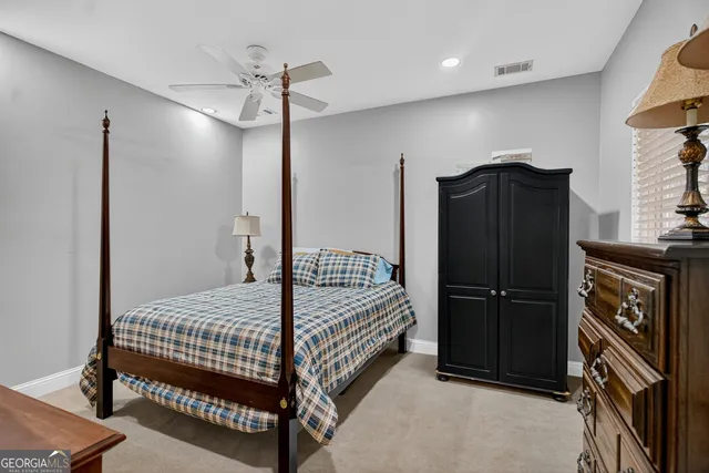 a bedroom with a bed a dresser and a chandelier