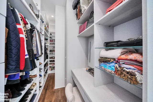 a view of walk in closet with clothes and shoes