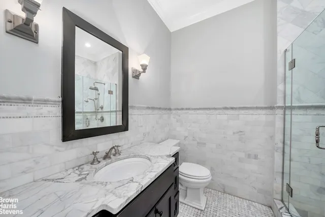a bathroom with a granite countertop toilet sink and mirror