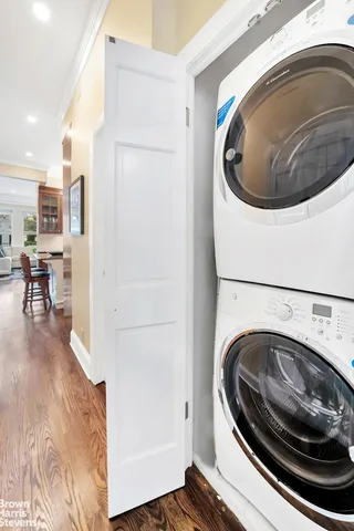 a utility room with wooden floor washer and dryer