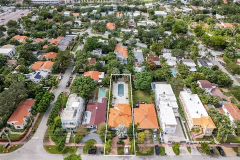 an aerial view of residential houses with outdoor space and trees
