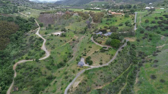 an aerial view of residential house with outdoor space and trees all around