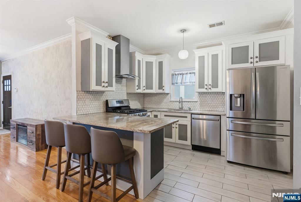 a kitchen with stainless steel appliances granite countertop a stove a sink a refrigerator and a refrigerator