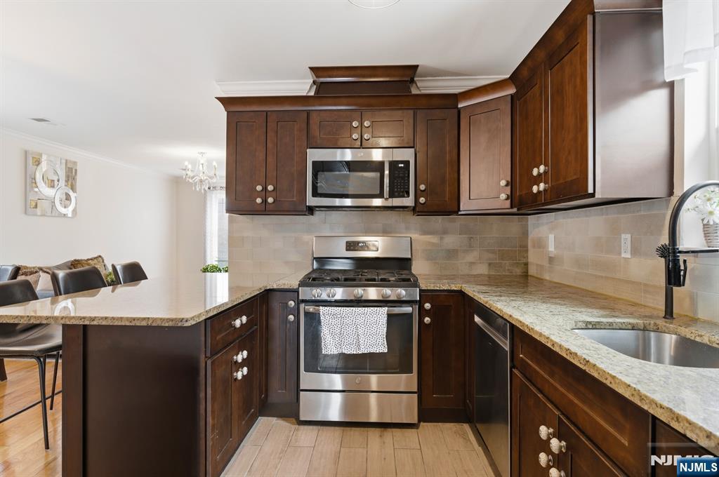 944 Flora Street Elizabeth, NJ 07201 - Photo 16 of 37 a kitchen with stainless steel appliances granite countertop a stove a sink and a microwave