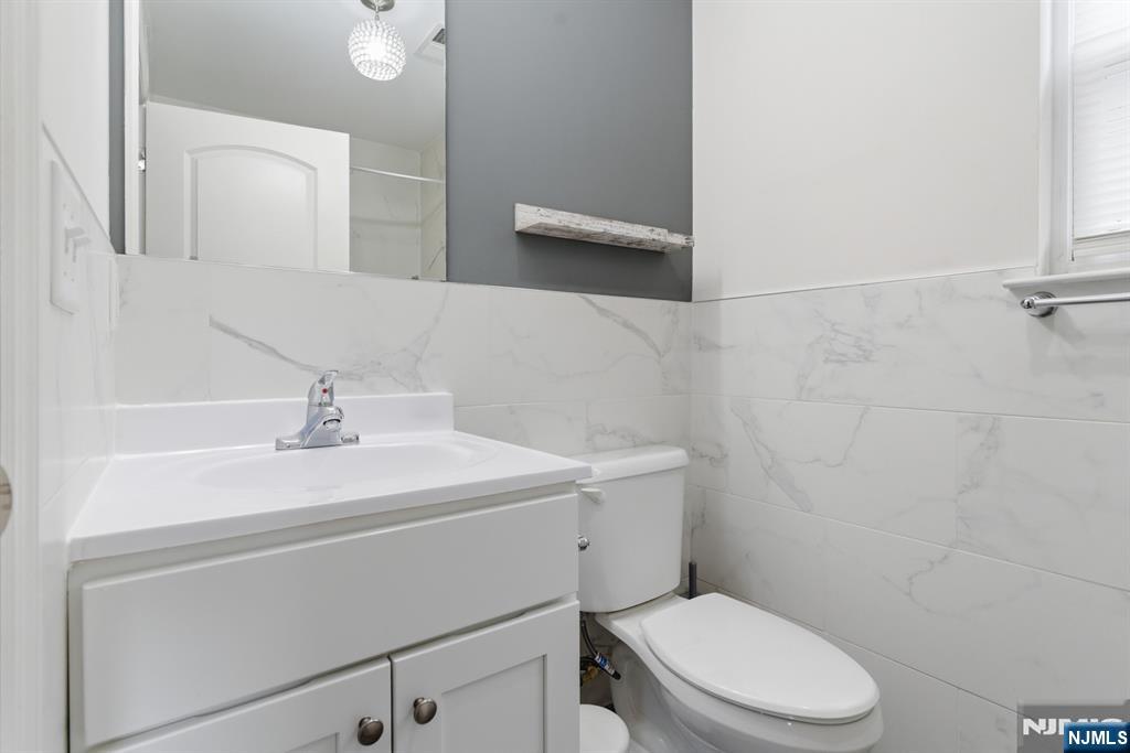 944 Flora Street Elizabeth, NJ 07201 - Photo 25 of 37 a bathroom with a sink a toilet and a mirror