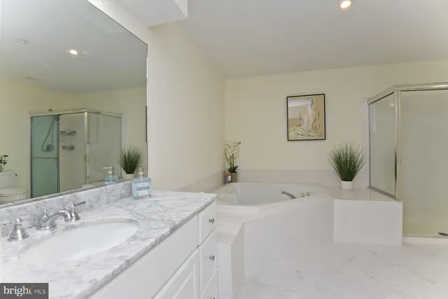 a bathroom with a granite countertop tub sink and mirror