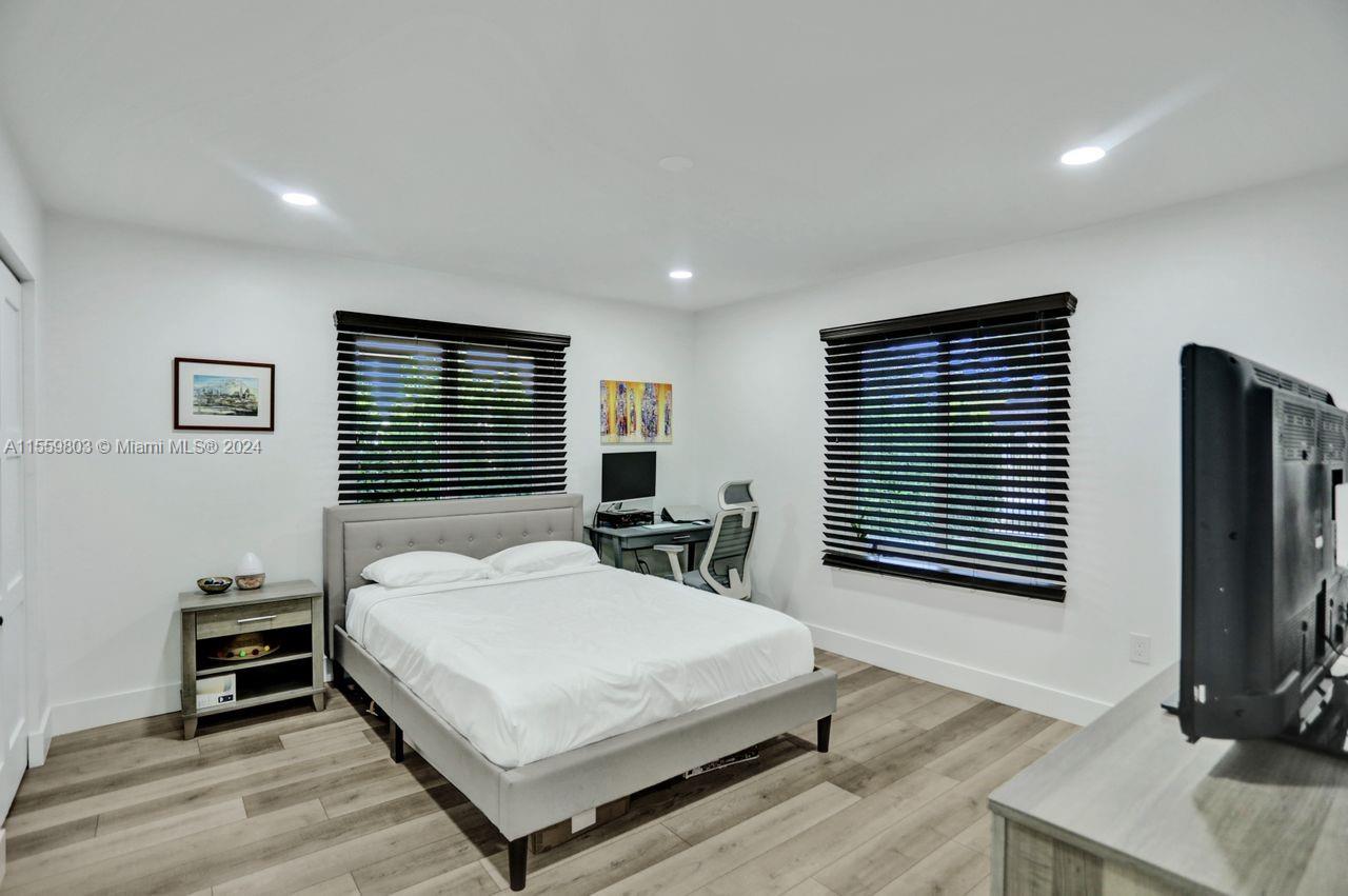 2800 Southwest 26th Street Miami, FL 33133 - Photo 46 of 72 a bedroom with a bed a tv and wooden floor