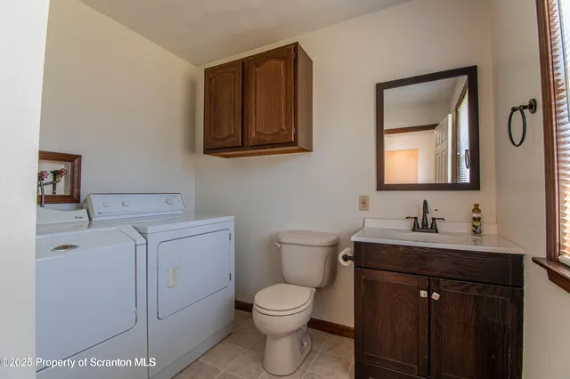 a bathroom with a toilet a sink a vanity and mirror
