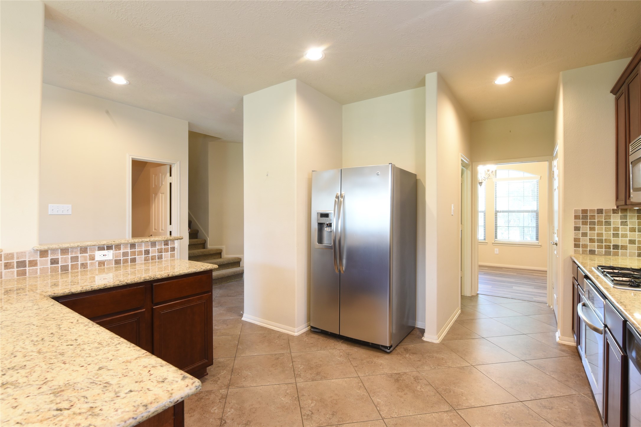 118 East Lasting Spring Circle Spring, TX 77389 - Photo 14 of 46 Modern kitchen with granite countertops, stainless steel appliances, and a spacious open layout leading to a bright dining area.