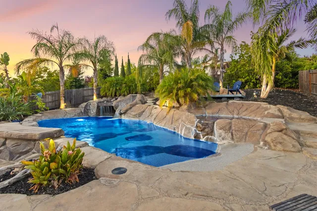 a view of a swimming pool with couches and a fire pit