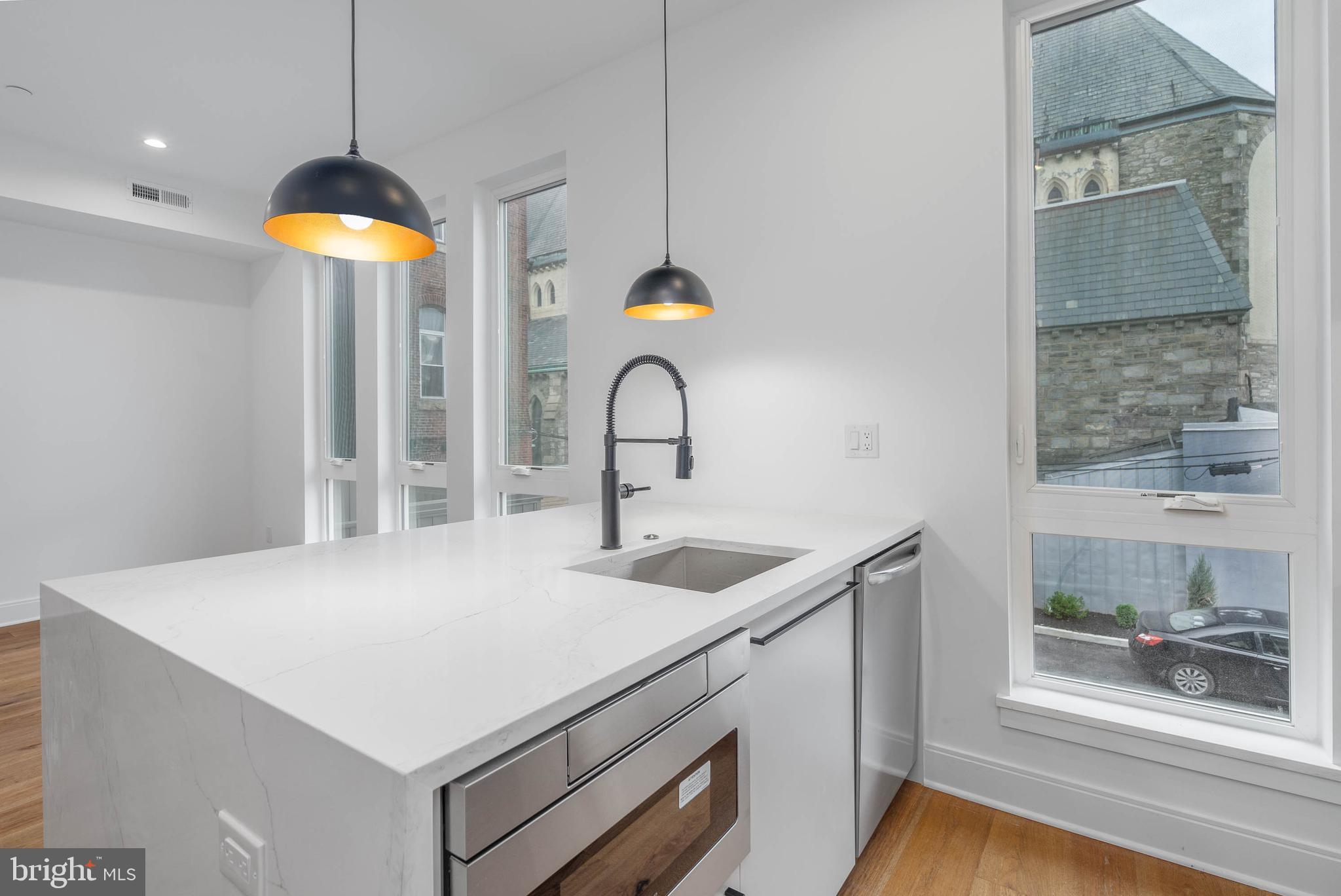 308 Reed Street, Unit 1 Philadelphia, PA 19147 - Photo 3 of 19 a kitchen with a sink a counter top space and a wooden floor