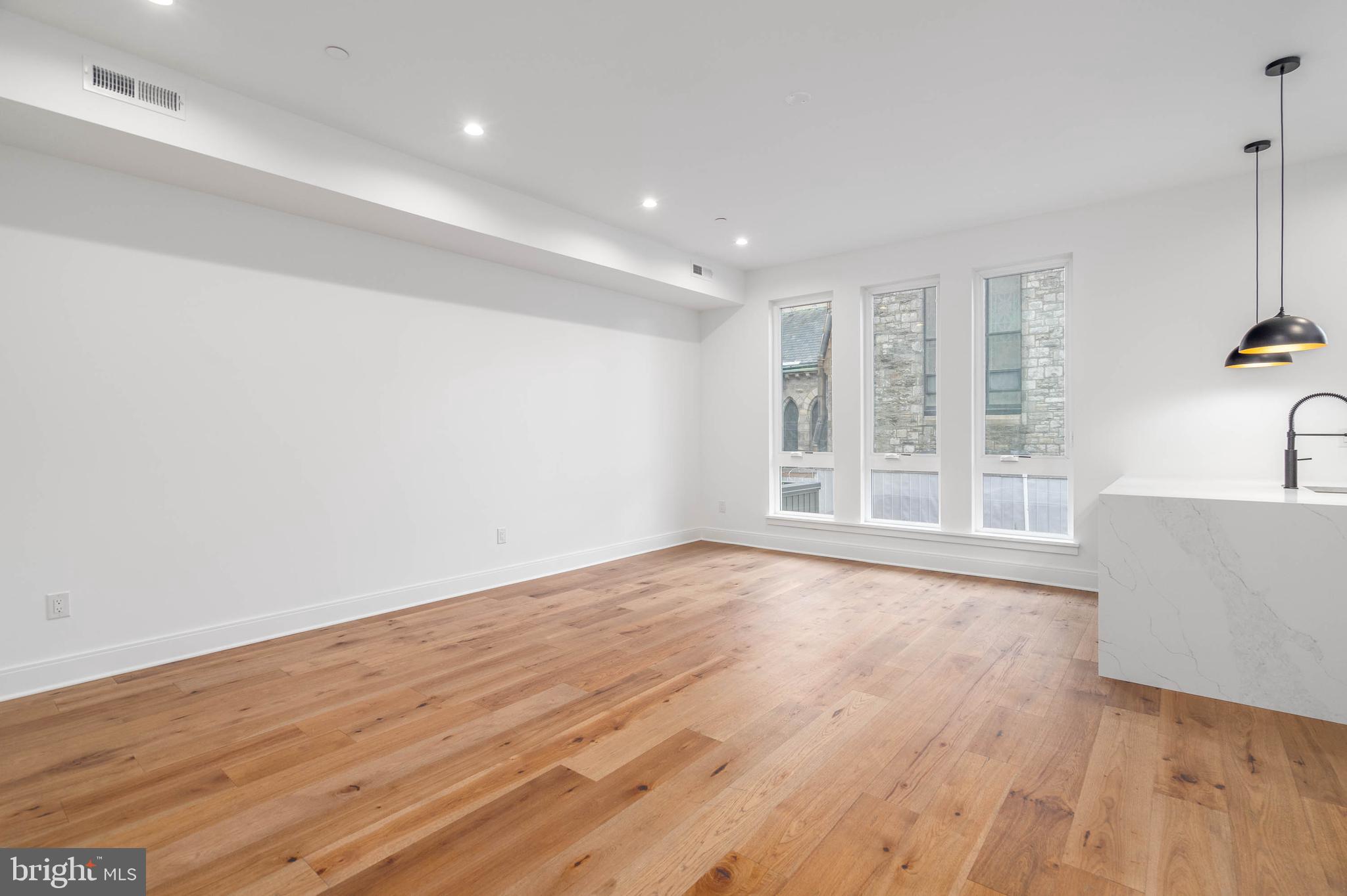 308 Reed Street, Unit 1 Philadelphia, PA 19147 - Photo 7 of 19 a view of an empty room with wooden floor and a window