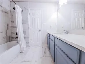 a bathroom with a sink vanity tub and shower