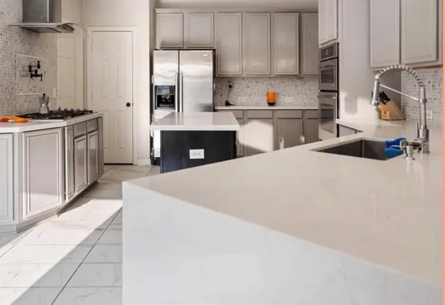 a kitchen with stainless steel appliances a sink and a refrigerator