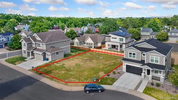 an aerial view of a house with swimming pool and large trees