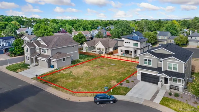 an aerial view of a house with swimming pool and large trees