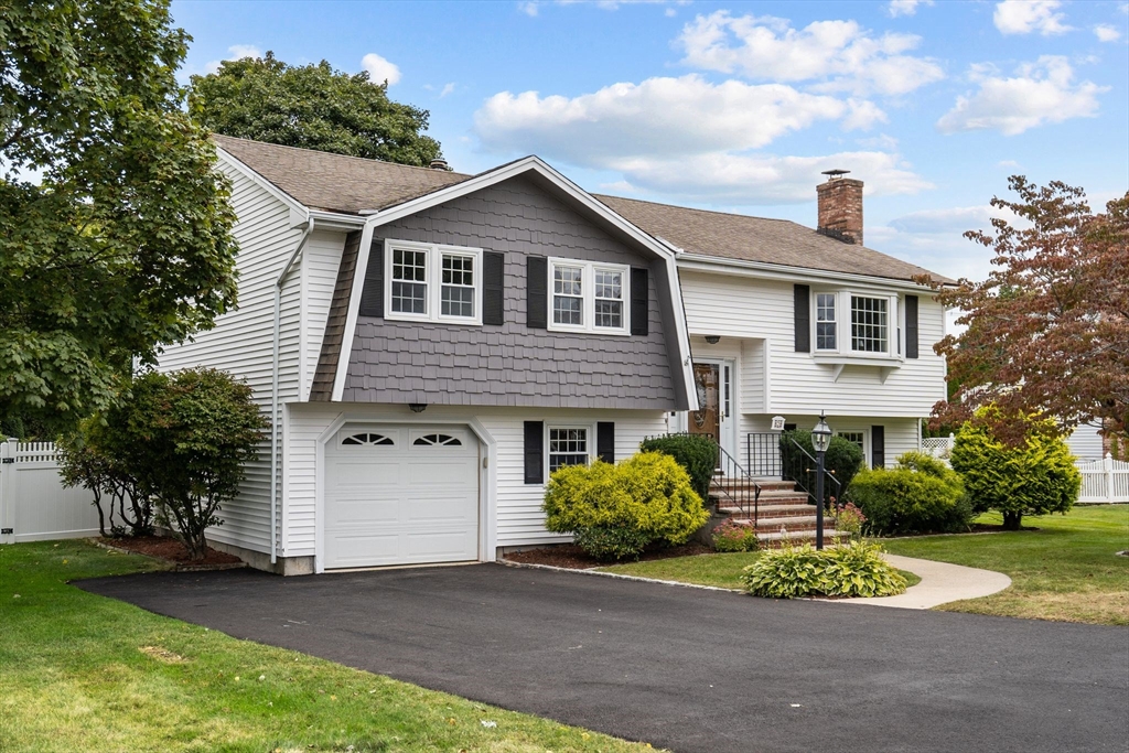 a front view of a house with a yard and trees