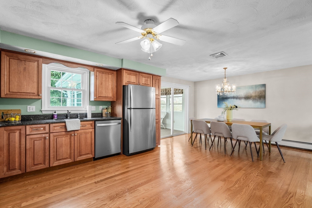 5 Brae Circle Woburn, MA 01801 - Photo 12 of 40 a kitchen with stainless steel appliances granite countertop a refrigerator a stove a sink dishwasher a dining table and chairs with wooden floor