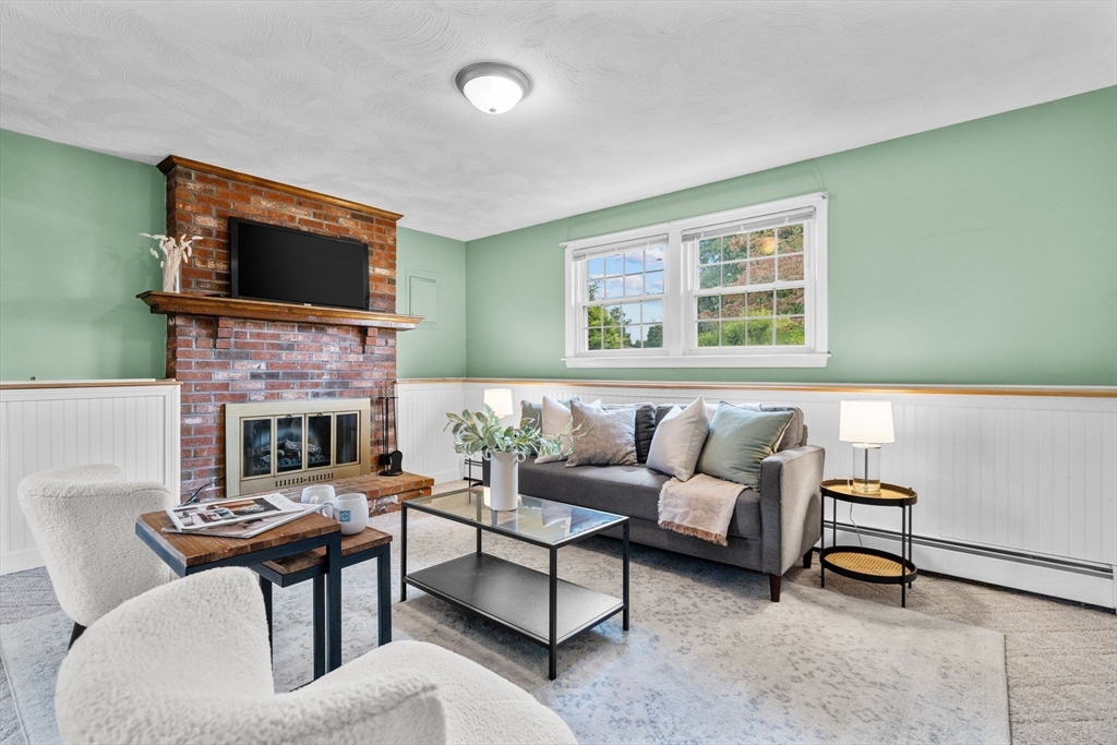 5 Brae Circle Woburn, MA 01801 - Photo 26 of 40 a living room with furniture a flat screen tv and a fireplace