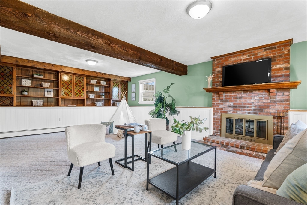 5 Brae Circle Woburn, MA 01801 - Photo 27 of 40 a living room with furniture a flat screen tv and a fireplace