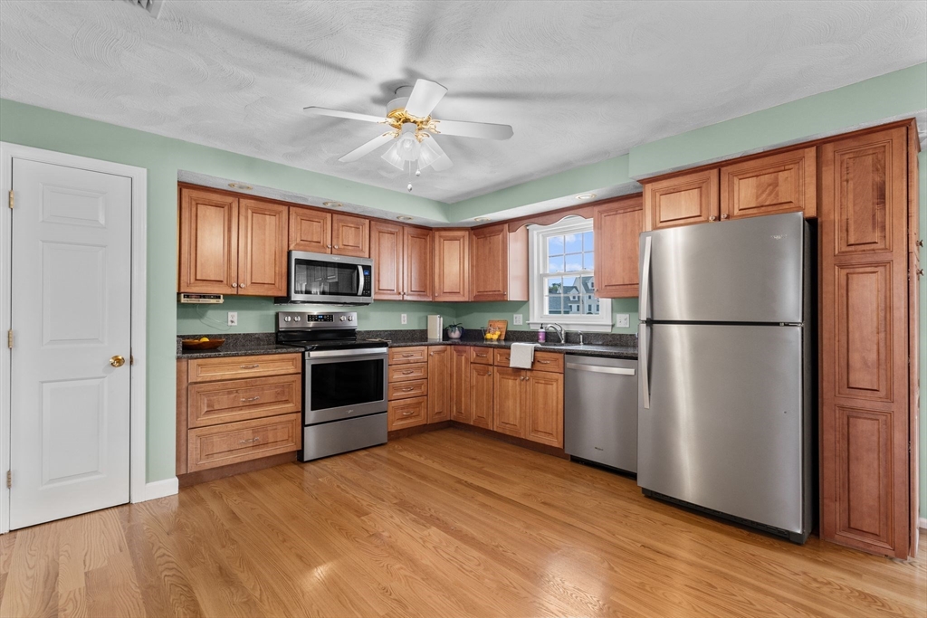 5 Brae Circle Woburn, MA 01801 - Photo 10 of 40 a kitchen with a refrigerator cabinets and wooden floor