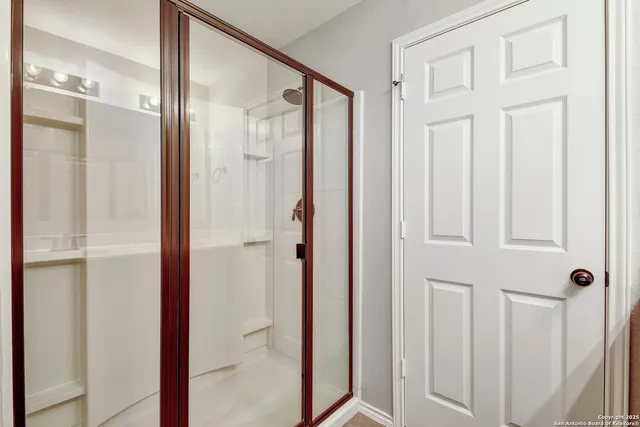 a bathroom with a glass shower door and a bathroom sink