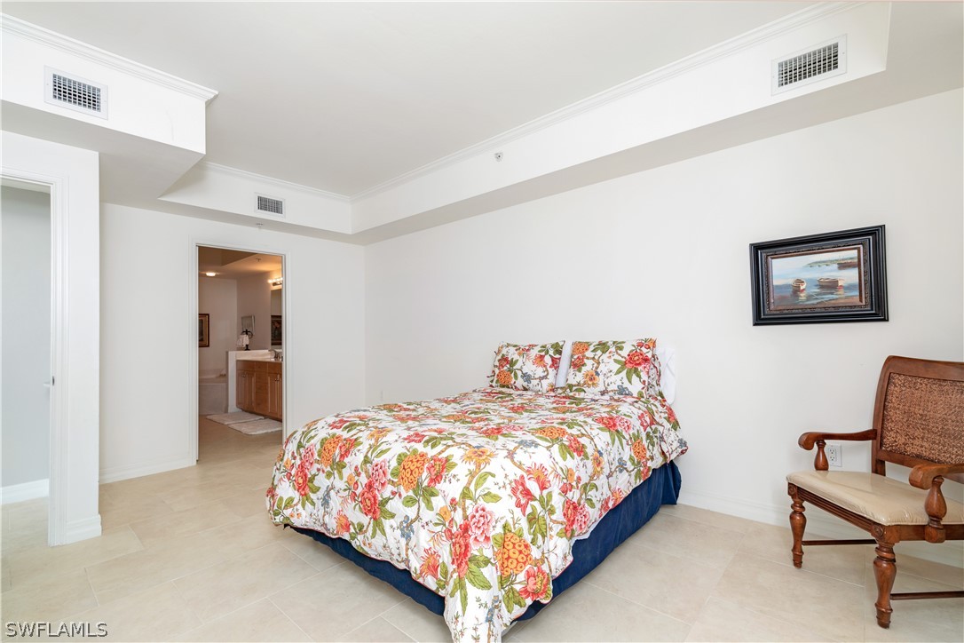 2797 First Street, Unit 1806 Fort Myers, FL 33916 - Photo 20 of 34 a large bed sitting in a bedroom next to a window with chair