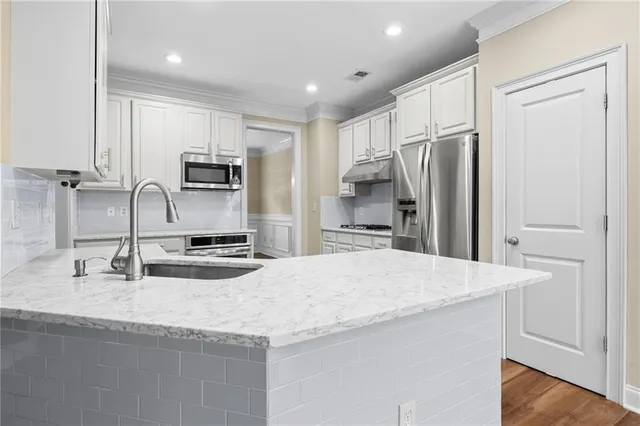 a kitchen with kitchen island granite countertop a sink refrigerator and microwave