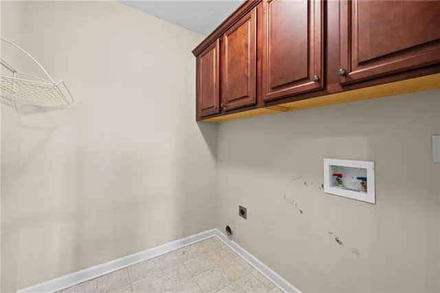 an empty room with chandelier fan and windows