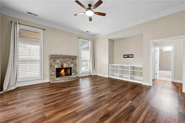 a view of a livingroom with wooden floor a fireplace and window