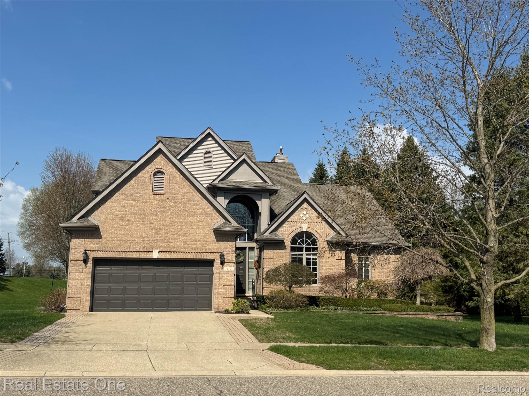 419 Roundview Drive Rochester, MI 48307 - Photo 1 of 29 View of front of property with a front lawn, concrete driveway, brick siding, and an attached garage