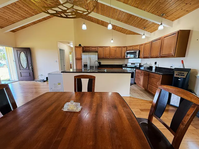a view of kitchen with microwave stove refrigerator dining table and chairs