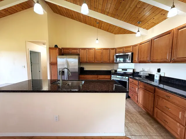 a kitchen with stainless steel appliances granite countertop a stove a sink and a microwave