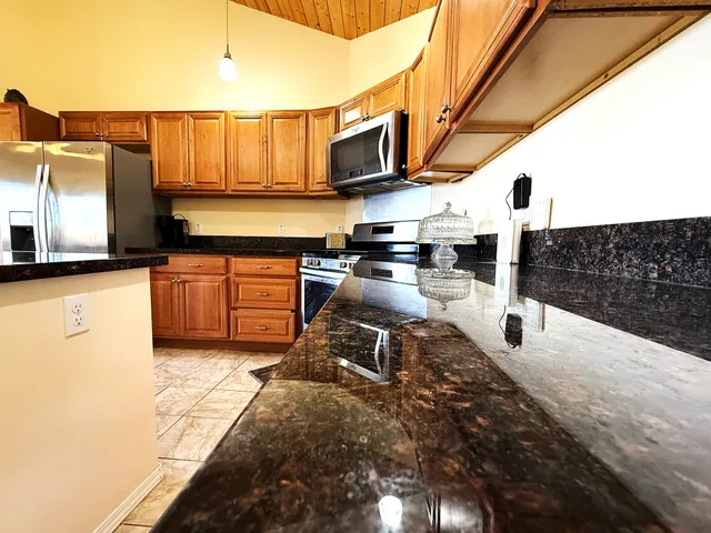 a kitchen with stainless steel appliances granite countertop a sink a stove and cabinets