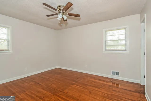 a view of an empty room with wooden floor