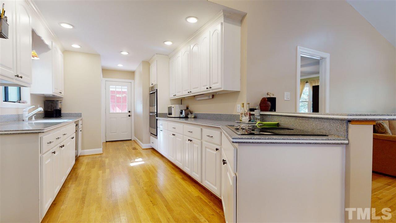 5901 Crabapple Road Durham, NC 27712 - Photo 12 of 20 a kitchen with granite countertop a sink and cabinets