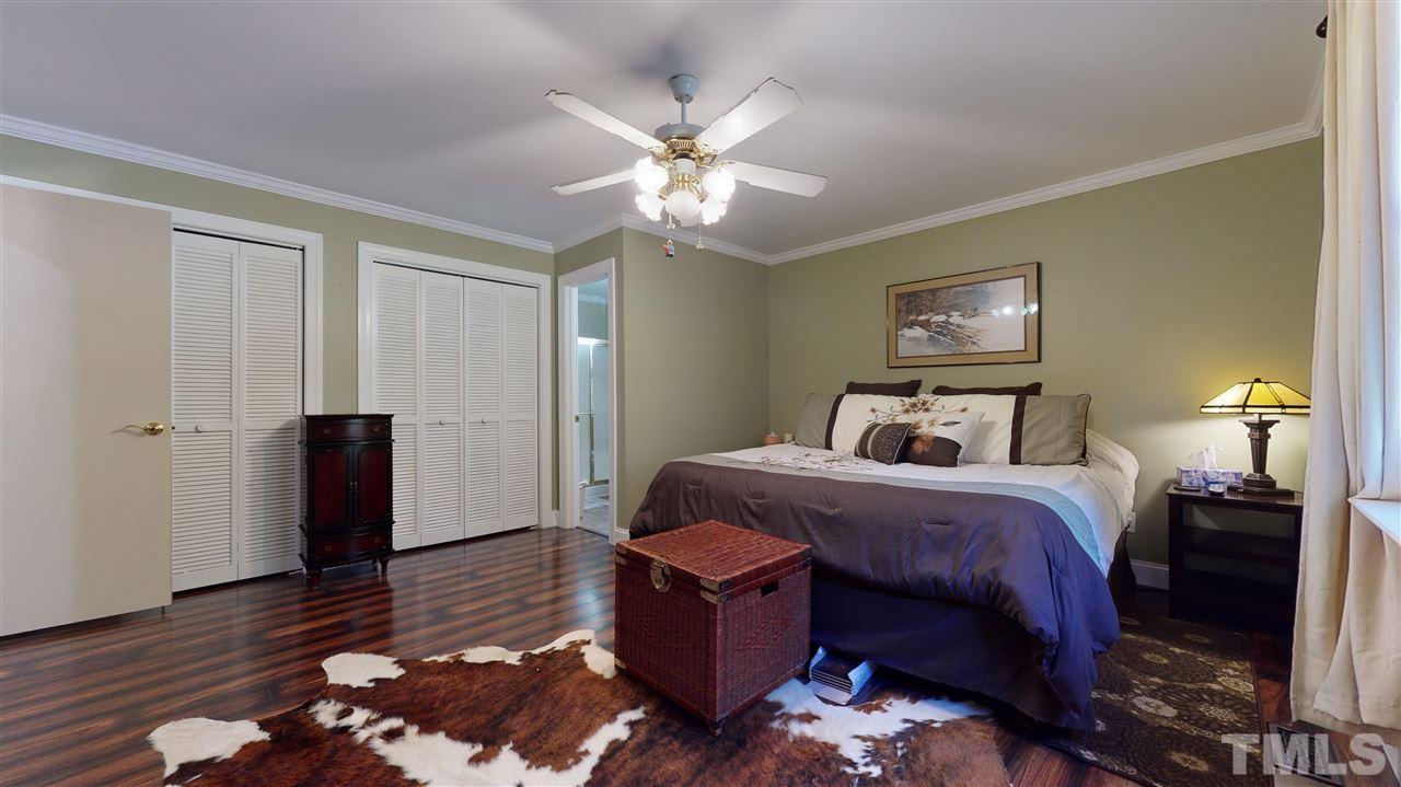 5901 Crabapple Road Durham, NC 27712 - Photo 14 of 20 a bed room with a bed and a chandelier