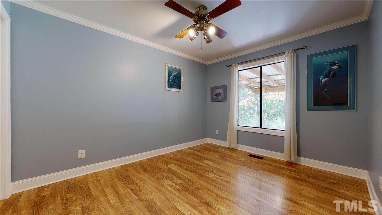 5901 Crabapple Road Durham, NC 27712 - Photo 16 of 20 a view of empty room with wooden floor and fan