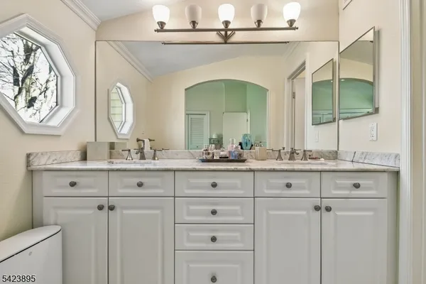 a bathroom with double vanity and a mirror