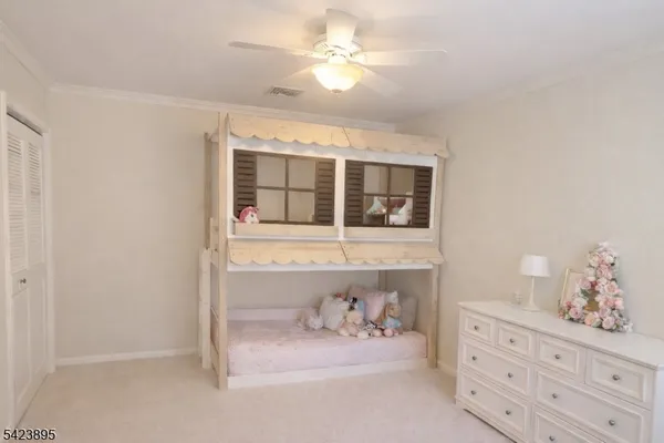a bedroom with a bed and a chandelier fan