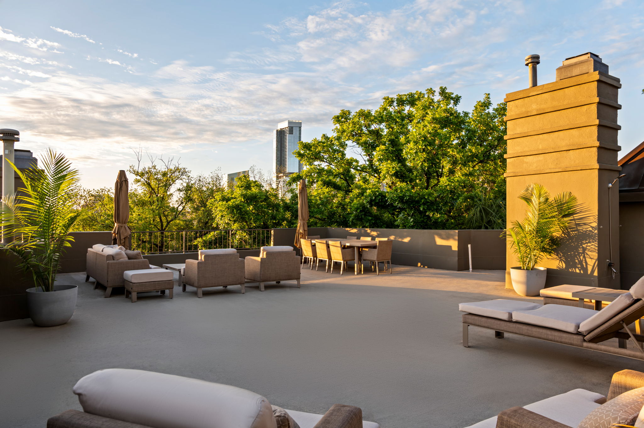 1111 West 12th Street, Unit 107 Austin, TX 78703 - Photo 2 of 38 Expansive rooftop terrace with a stucco chimney stack, parapet walls, and a dedicated dining area