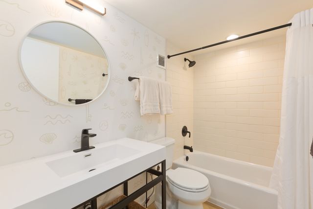 a bathroom with a sink a toilet and a mirror