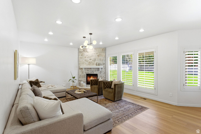 1712 Somerset Ridge Drive Draper, UT 84020 - Photo 26 of 76 Spacious living area featuring a stone fireplace with a white mantel, light wood-finish flooring, recessed lighting, and multiple windows with white plantation shutters