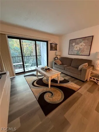 a living room with furniture and a floor to ceiling window