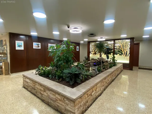 a living room with furniture and potted plants